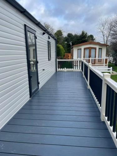 a wooden walkway leading to a building with a door at Dog and Duck Leisure Park in Kent