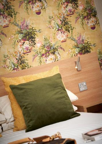 a bedroom with a bed with a floral wallpaper at Kingston Theatre Hotel in Hull