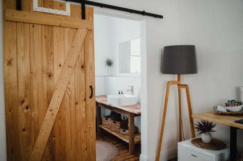 a bathroom with a wooden door and a sink at I Gemütliches 1-Zimmer-Apartment & eigenes Bad I in Neuendorf