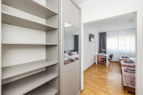 a room with white shelves and a mirror at Sport Hotel in Jelenia Góra