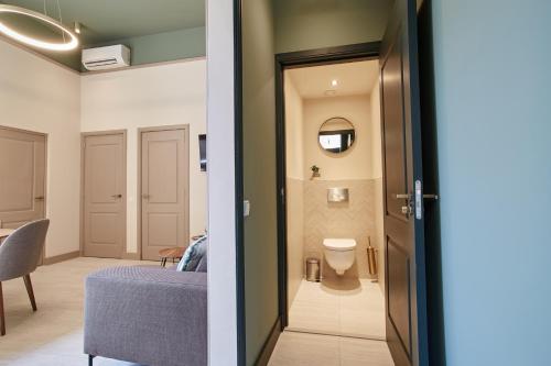 a hallway with a room with a bed and a bathroom at Seaside design apartment in Scheveningen