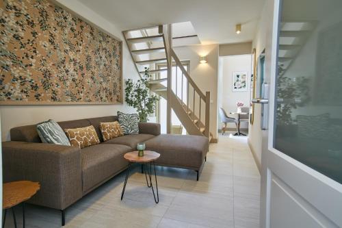 a living room with a couch and a staircase at Seaside design apartment in Scheveningen