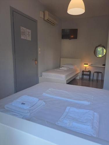 a bedroom with two beds with towels on the bed at Studios Αποστόλης Selianitika in Aígio