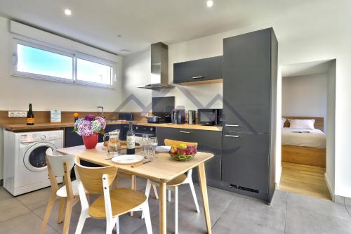 a kitchen and dining room with a table and chairs at LocaLise - M44 - Ty Juzolie -Maison de plain-pied avec jardin clos à deux pas du centre, du port et des plages du Guilvinec - Wifi inclus - Linge de lit inclus - Animaux bienvenus in Le Guilvinec