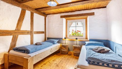 deux lits dans une chambre avec plafonds en bois dans l'établissement Schwarzwald - Ferienhaus In, à Villingen-Schwenningen