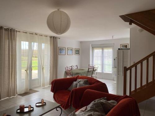 un chien dormant dans une chaise rouge dans un salon dans l'établissement Le Chèvrefeuille, à Cerelles