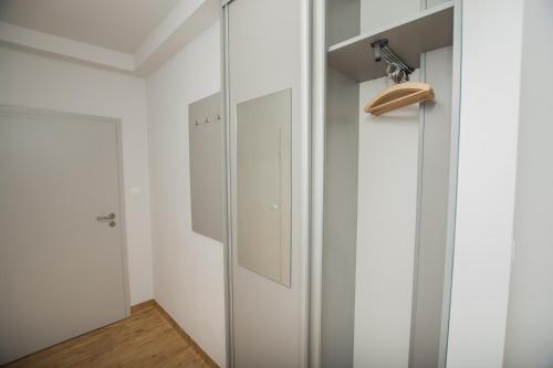 a closet with white cabinets and a mirror at Sport Hotel in Jelenia Góra