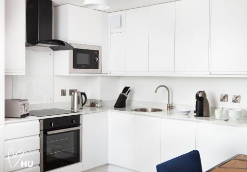 a white kitchen with white cabinets and appliances at Boutique 1 Bedroom Duplex Suite on Marina-304 in Hull