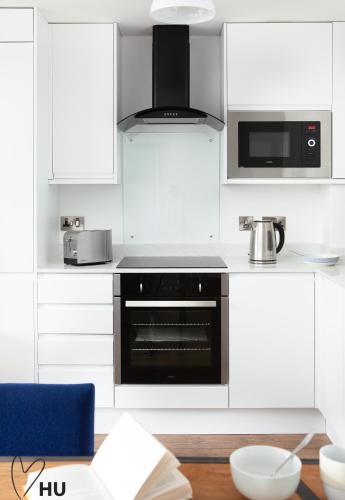 a kitchen with white cabinets and a black oven at Boutique 1 Bedroom Duplex Suite on Marina-304 in Hull