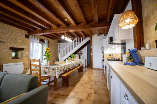 une cuisine et une salle à manger avec une table et des chaises dans l'établissement Nid douillet des oiseaux, à Saint-Crépin-et-Carlucet
