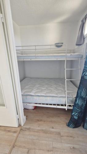 une chambre avec deux lits superposés dans une pièce dans l'établissement Le Corail Grand studio Vue mer avec loggia - Plage et port à 5 min à pied - parking privatif - Draps et ménage inclus, à Saint-Cyprien
