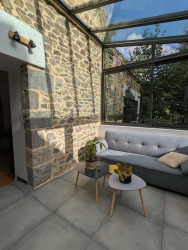 un salon avec un canapé et deux tables dans l'établissement Maison de campagne au bord du ruisseau-5mn mer, à Lamballe Armor