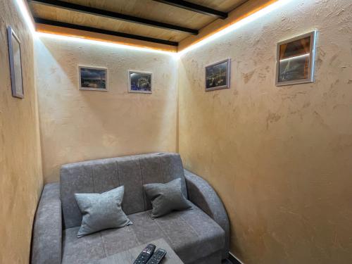 a couch in a room with a remote control at APARTMAN OAZA 24 in Surčin