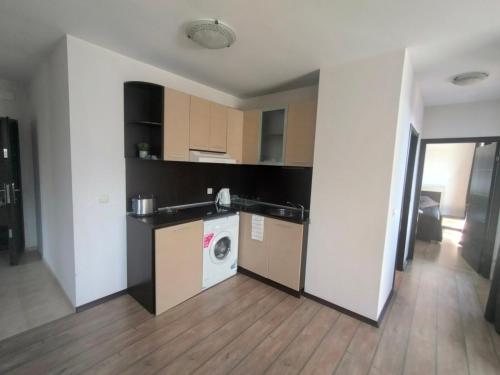 a kitchen with a washing machine in a room at Alpine Lodge Bansko Apartments in Bansko