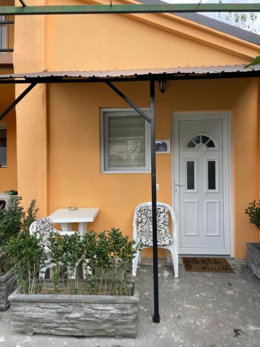 a house with a white door and a table and chairs at APARTMAN OAZA 24 in Surčin