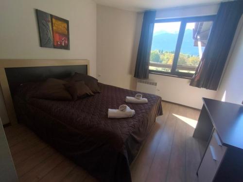 a bedroom with a bed with two towels on it at Alpine Lodge Bansko Apartments in Bansko