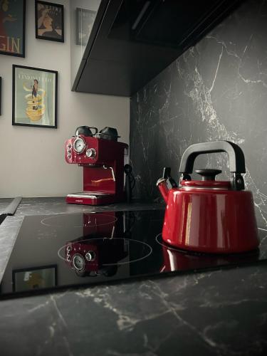 a red tea kettle sitting on top of a counter at Metro Trocka Apartment in Warsaw