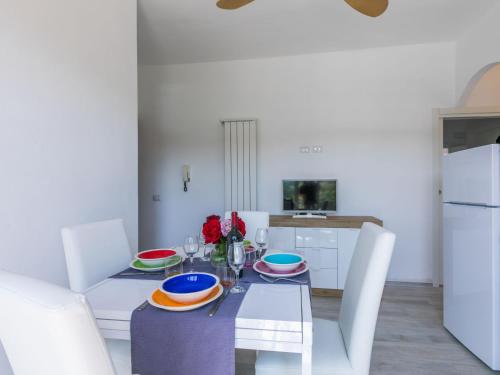 a white dining room with a table and chairs at Apartment Mauro by Interhome in San Vincenzo