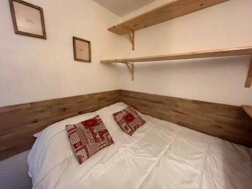une chambre avec un lit blanc avec deux oreillers dessus dans l'établissement Studio Asters 323 Bâtiment A1 by Interhome, aux Menuires
