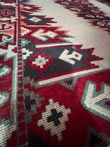 a close up of a red rug with patterns on it at The GREEN FAMILY paradise in Čajetina