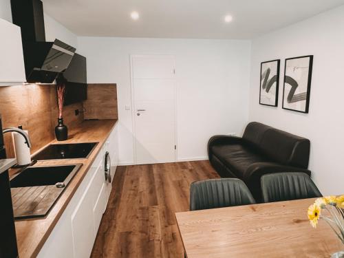 a living room with a couch and a kitchen at Melem Apartments in Langen