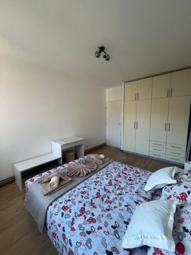 a bedroom with a bed with a blue blanket and white cabinets at The GREEN FAMILY paradise in Čajetina