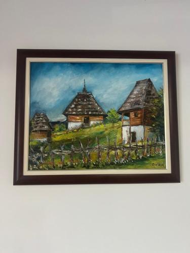 a framed painting ofvillages on a wall at The GREEN FAMILY paradise in Čajetina