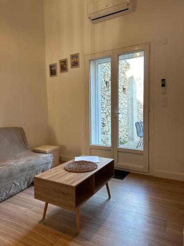 a room with a bed and a table and a window at Maison cosy rénovée, proche de Carcassonne in Villarzel-Cabardès