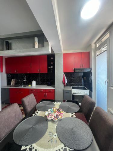 a kitchen with red cabinets and a table and chairs at The GREEN FAMILY paradise in Čajetina