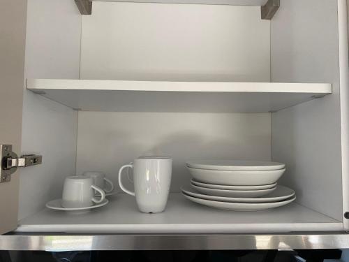 a shelf with plates and cups on it at RoSea B&B Formia in Formia