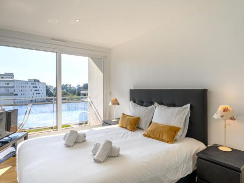 une chambre avec un grand lit blanc avec une grande fenêtre dans l'établissement Apartment Men Er Bellec-3 by Interhome, à Saint-Philibert