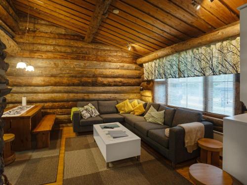 ein Wohnzimmer mit einem Sofa in einem Blockhaus in der Unterkunft Holiday Home Kaukonkelo by Interhome in Rukatunturi 