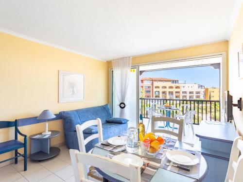 un salon avec un canapé bleu et une table dans l'établissement Apartment Les Marines-6 by Interhome, à La Foux