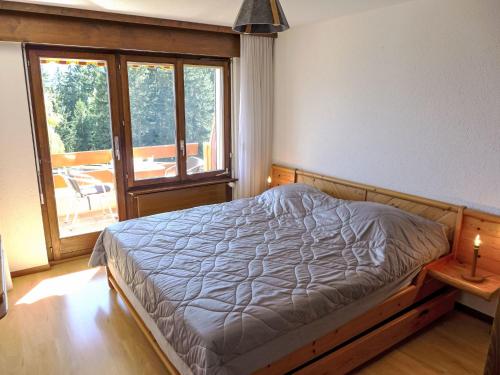 a bedroom with a bed and a large window at Apartment Terrasse des Alpes 2006 by Interhome in Crans-Montana