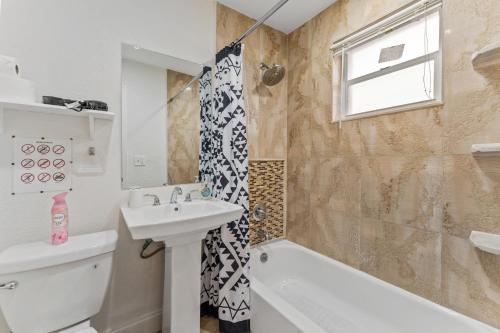 Un baño con lavabo, inodoro y ducha. en Spacious 5BR Home with Pool, Near Downtown & Beach, en Hollywood