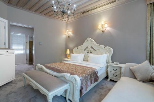 a bedroom with a large white bed and a couch at Elegance East Hotel in Antalya
