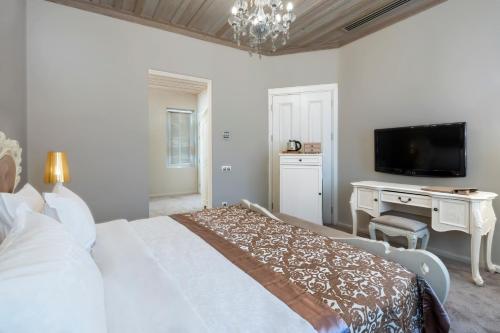 a bedroom with a bed and a desk and a tv at Elegance East Hotel in Antalya