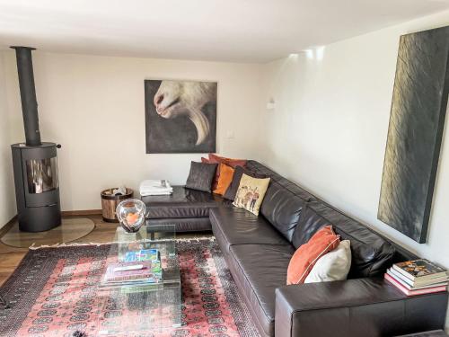 a living room with a black leather couch at Holiday Home Chalet Tannengüetli by Interhome in Grindelwald