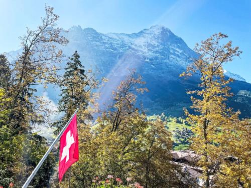 a canadian flag flying in front of a mountain at Holiday Home Chalet Tannengüetli by Interhome in Grindelwald