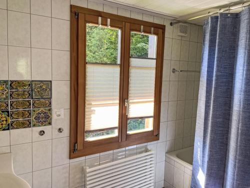 a bathroom with a window and a shower curtain at Holiday Home Chalet Tannengüetli by Interhome in Grindelwald