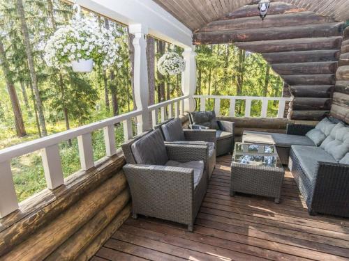 a screened in porch with chairs and a table at Holiday Home Villa kallahti beach view helsinki by Interhome in Helsinki