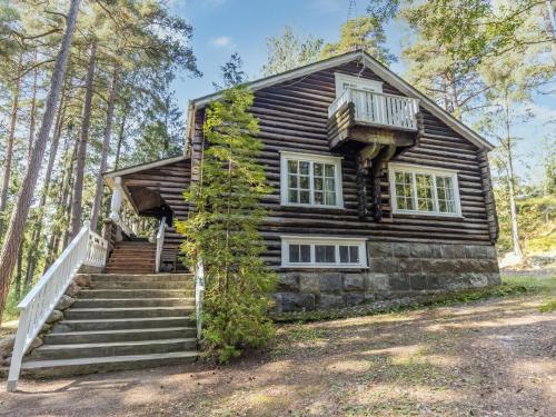 a log cabin with stairs and a balcony at Holiday Home Villa kallahti beach view helsinki by Interhome in Helsinki