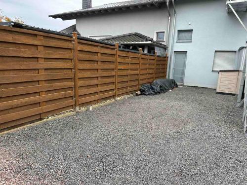 a wooden fence in front of a house at Große Ferienwohnung Gästehaus NEUBAU Merzig 120m2 in Merzig
