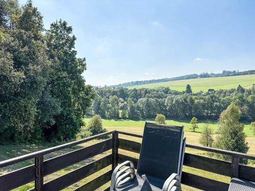 a person sitting on a fence looking at a field at Holiday Home Stárkov by Interhome in Stárkov