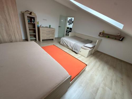 a bedroom with two beds and an orange rug at Große Ferienwohnung Gästehaus NEUBAU Merzig 120m2 in Merzig