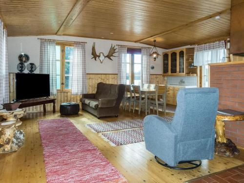 a living room with a blue chair and a television at Holiday Home Ounasmosku by Interhome in Tepasto