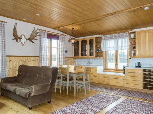 a kitchen and dining room with a couch and a table at Holiday Home Ounasmosku by Interhome in Tepasto