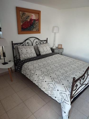 une chambre avec un lit avec une couette noire et blanche dans l'établissement Le JASMIN, à Mandelieu-la-Napoule