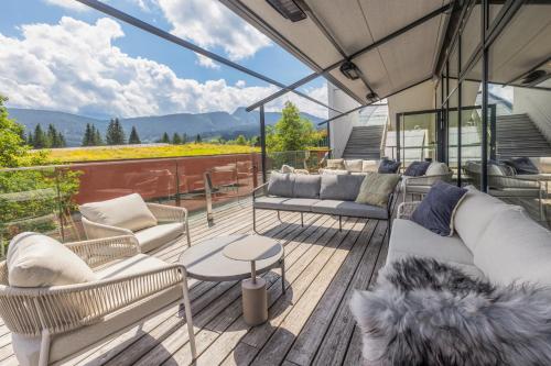 a deck with couches and a table and chairs at Aldiana Club Salzkammergut und GrimmingTherme in Bad Mitterndorf