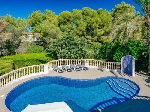 einen Pool mit Chaiselongues neben einem Zaun in der Unterkunft Holiday Home La Selva by Interhome in Jávea